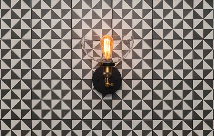 Modern wall sconce mounted on geometric tile in a contemporary Colorado interior design project